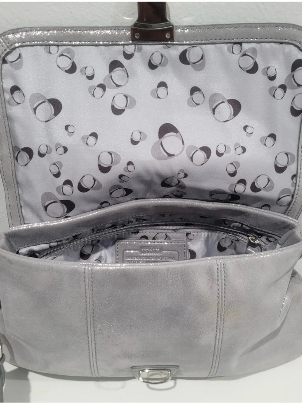 Coach Poppy Layla shimmery leather shoulder bag with a push-lock closure.